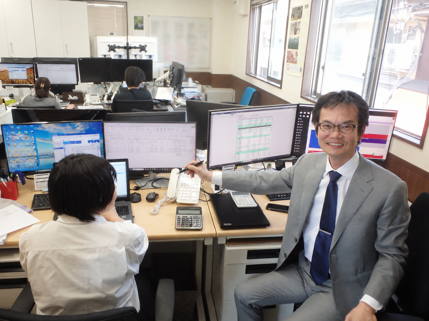 代表社員税理士 榎嶋隆司が日々スタッフへ業務指導を行う様子|タックス・プラン税理士法人 本社執務室