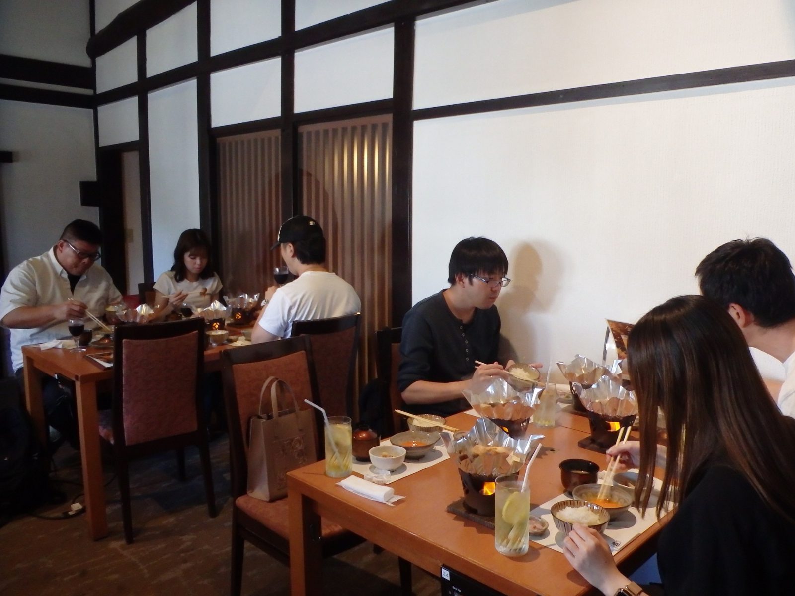 和の雰囲気の店内で、近江牛のすき焼きを味わう社員たち